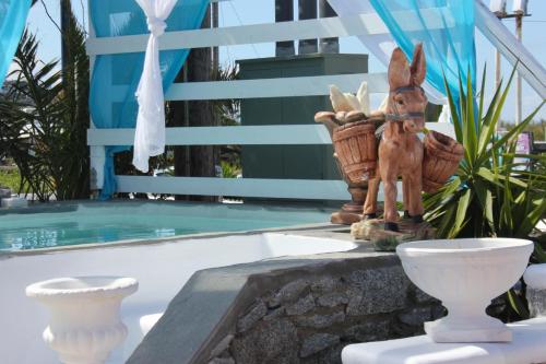 a statue of a donkey sitting next to a pool at Dibellee Mykonos Studios in Glastros