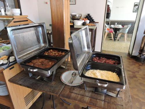 two trays of food on a counter in a kitchen at L auberge du lion d or in Nanteuil-sur-Marne