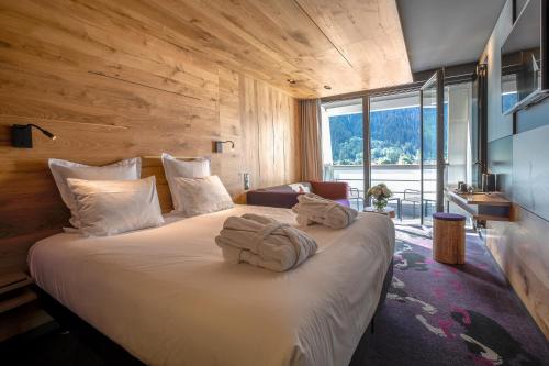 Una habitación de hotel con una cama con toallas. en Alpina Eclectic Hotel, en Chamonix-Mont-Blanc