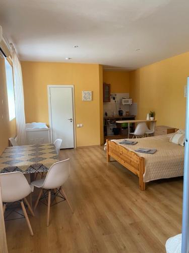 a room with a table and a bed and a kitchen at Kuru Guest House in Kuru
