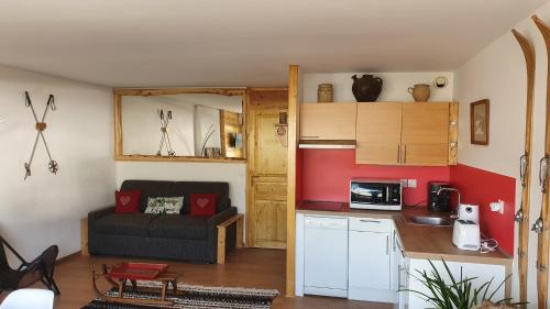 a kitchen and a living room with a couch at Studio chaleureux station de Serre Chevalier 1200 (Briançon) in Briançon