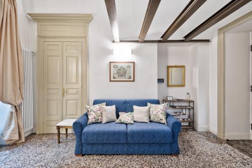 - un canapé bleu dans le salon avec plafond dans l'établissement Apartments to Art, à Turin