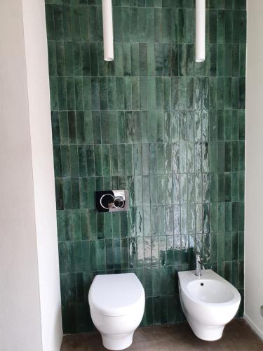 a green tiled bathroom with a toilet and a sink at Casa Lunaria B&B in Porto SantʼElpidio