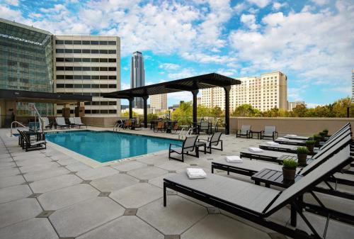um pátio no último piso com uma piscina, mesas e cadeiras em Holiday Inn Express - Houston - Galleria Area, an IHG Hotel em Houston