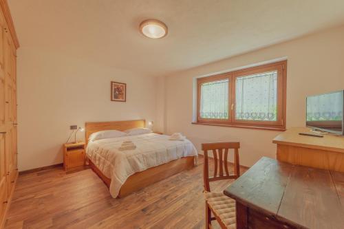 een slaapkamer met een bed en een bureau met een computer bij CASA JASMIN - Scopri le bellezze di Courmayeur - COUR 0154 in Courmayeur