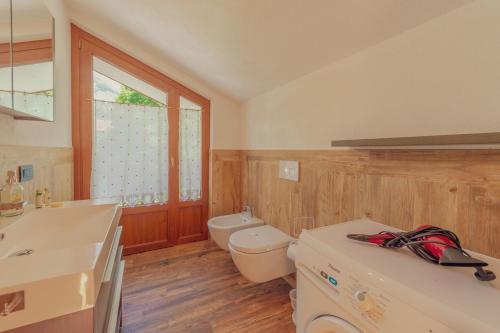 een badkamer met een wastafel en een toilet en een raam bij CASA JASMIN - Scopri le bellezze di Courmayeur - COUR 0154 in Courmayeur