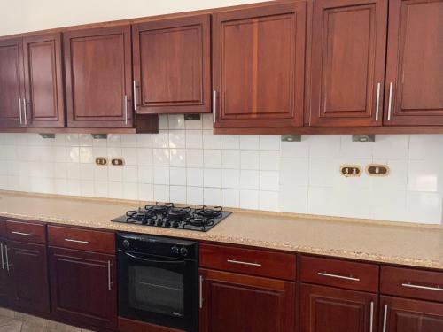 a kitchen with wooden cabinets and a stove top oven at Ocean Breeze Villa Carismar in Cabrera
