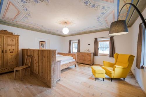 a bedroom with a bed and a couch and a chair at Ausserwegerhof in Anterselva di Mezzo