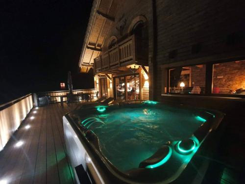 a jacuzzi tub with green lights in a building at Nouveau Chalet M.META 12 pers sauna,jacuzzi,billard in Xonrupt-Longemer