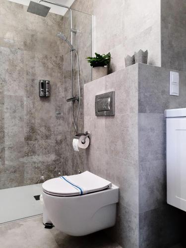 a bathroom with a white toilet and a shower at Apartament w Centrum in Zamość
