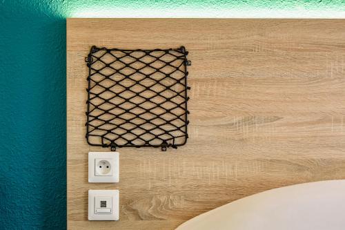 a wall with a black mesh on it and two outlets at hotelF1 Calais Coquelles in Coquelles