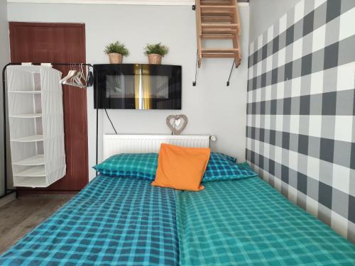 ウストカにあるKomfortowy pokój DOMIのオレンジ枕付きのベッド1台