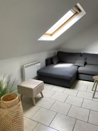 a living room with a couch and a skylight at Atelier Voyageur in Chartres