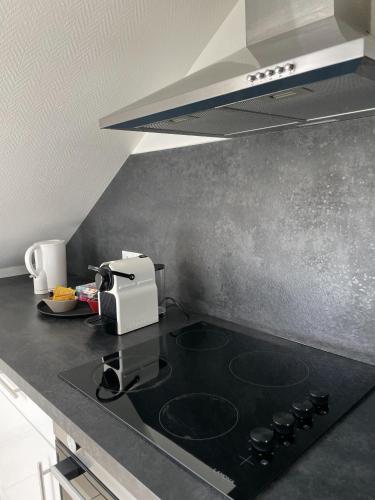 a kitchen with a black counter top with a stove at Atelier Voyageur in Chartres