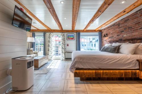 a bedroom with a bed and a brick wall at The Barnstead Inn in Manchester Center