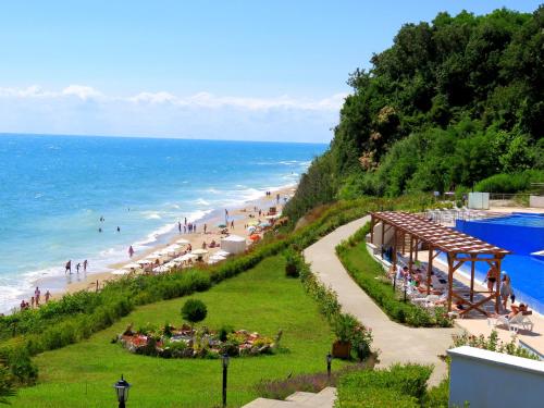 a beach with a group of people and the ocean at Бяла Клиф Форест - Byala Cliff Forest in Byala