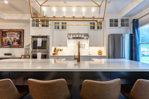 a kitchen with a large white island with chairs at The Barnstead Inn in Manchester Center