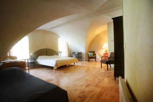 une chambre avec un lit, une table et des chaises dans l'établissement La Maison du Pont Vieux, à Cazilhac