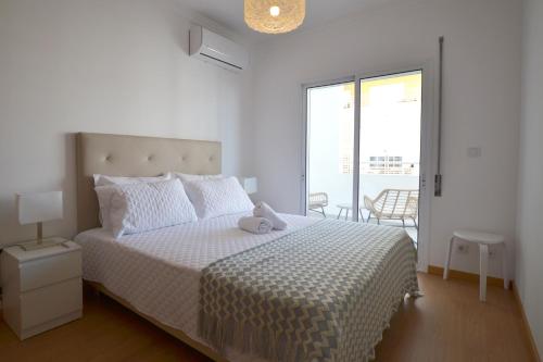 um quarto branco com uma cama e uma varanda em Top Refuge by ALgest em Portimão