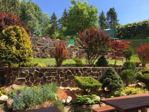 a garden with a stone wall and some plants at Vila Marko in Nová Lesná