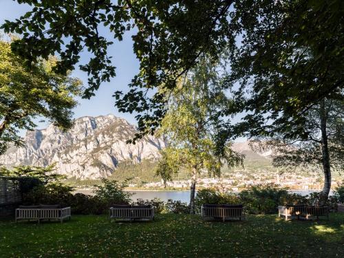 a park bench overlooking a lake and mountains at Casa Sull'Albero in Malgrate
