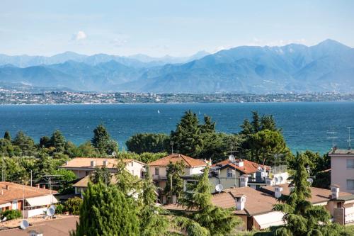 una ciudad con vistas al agua y a las montañas en Hotel Villa Maria, en Desenzano del Garda