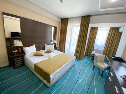 Cette chambre comprend un grand lit et un bureau. dans l'établissement Hotel Nevada, à Constanţa