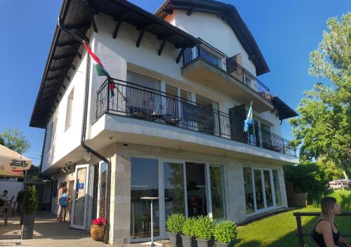 a building with a balcony on top of it at Duna P'Art Panzió in Verőce