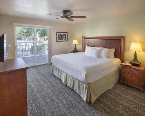 a bedroom with a large bed and a balcony at WorldMark St. George in St. George