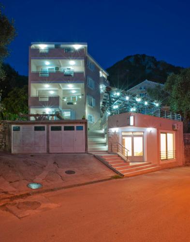 a house with a garage and a building with lights at Apartments Marina in Sveti Stefan