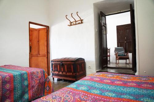 a bedroom with two beds and a mirror and a chair at Casa Rural Vata Pampaneira Alpujarra in Pampaneira
