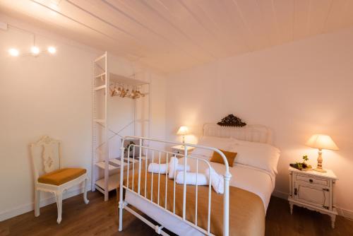 a bedroom with a white bed and a chair at AM21 in Ventosa