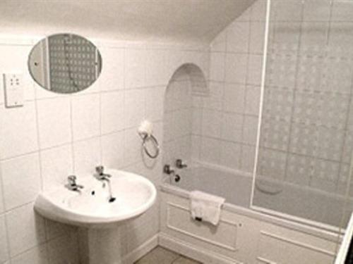 a bathroom with a sink and a tub and a mirror at Mather House Retreat in Wantage