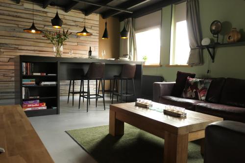 a living room with a couch and a table at Appartement ' Het Zilte'. in Yerseke