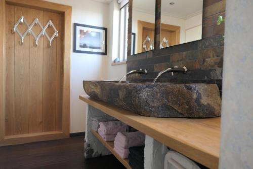 een badkamer met een grote stenen wastafel op een aanrecht bij Appartement ' Het Zilte'. in Yerseke
