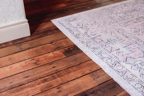 a rug on the floor of a room with wooden floors at The Rabbit Hotel & Retreat in Templepatrick