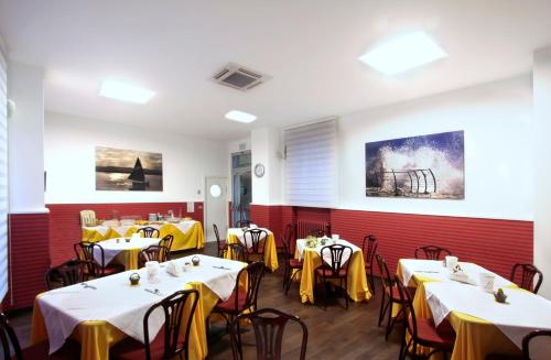 uma sala de jantar com mesas e cadeiras com guardanapos amarelos em Hotel Centrale em San Benedetto del Tronto