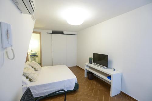 a small room with a bed and a tv at San Domenico in Bari