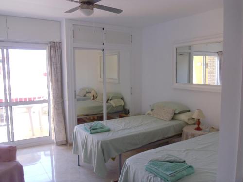 a bedroom with two beds and a window at Studio in Hercules with pool and sea view in Benalmádena