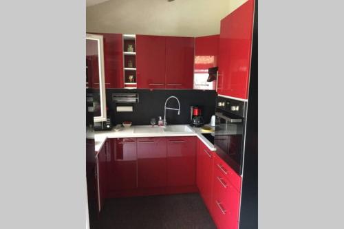 - une cuisine avec des placards rouges et un évier blanc dans l'établissement MAZET 6 pers. (Piscine) 20 mn de FREJUS/St MAXIME, à Plan Florent