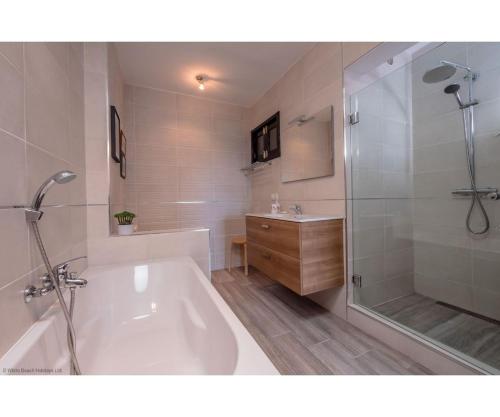 a bathroom with a tub and a shower and a sink at Puerto Chico I and J in Playa Blanca