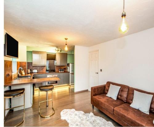 a living room with a couch and a kitchen at Elegant 2 BR Apartment in Historic Cambridge in Papworth Everard