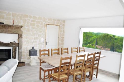 une salle à manger avec une table et des chaises et une cheminée dans l'établissement Villa complète au calme avec vue imprenable, à Beausemblant