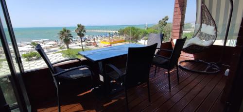 a table and chairs on a balcony with a view of the beach at Luxury Beach Apartment in Qerret in Golem