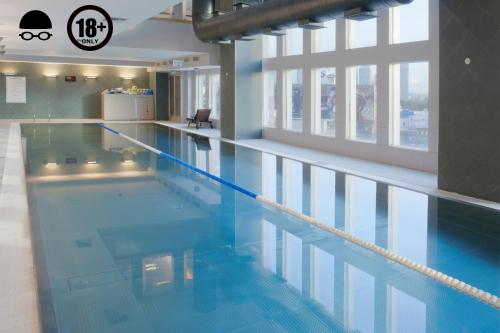 a large swimming pool with blue water in a building at Crowne Plaza Tel Aviv City Center, an IHG Hotel in Tel Aviv
