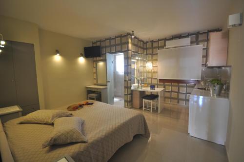 a room with a bed and a kitchen with a refrigerator at Ariadnes Holiday Accommodation in Apidias Lakos