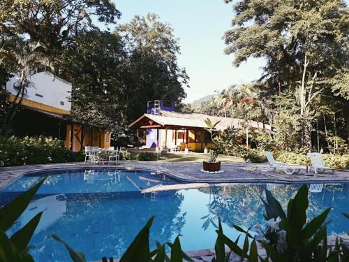 uma piscina em frente a uma casa em Casa Linda - Piscina Ampla - Jacuzzi - Imenso Jardim em São Sebastião