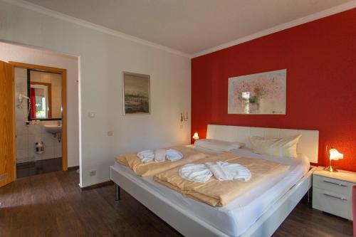 a bedroom with a large bed with a red wall at Hotel Im Schwedischen Hof in Binz