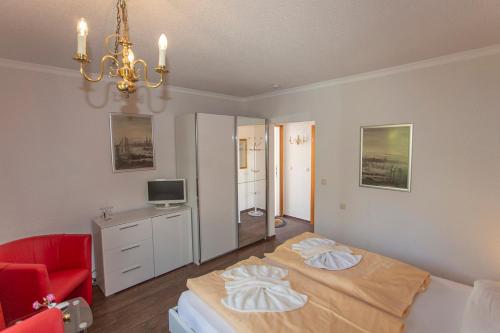 a bedroom with a bed and a red chair at Hotel Im Schwedischen Hof in Binz
