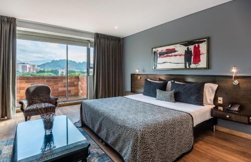 a hotel room with a bed and a window at Hotel Egina Medellin in Medellín